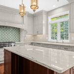 White kitchen perimeter cabinets with a dark cherry island.