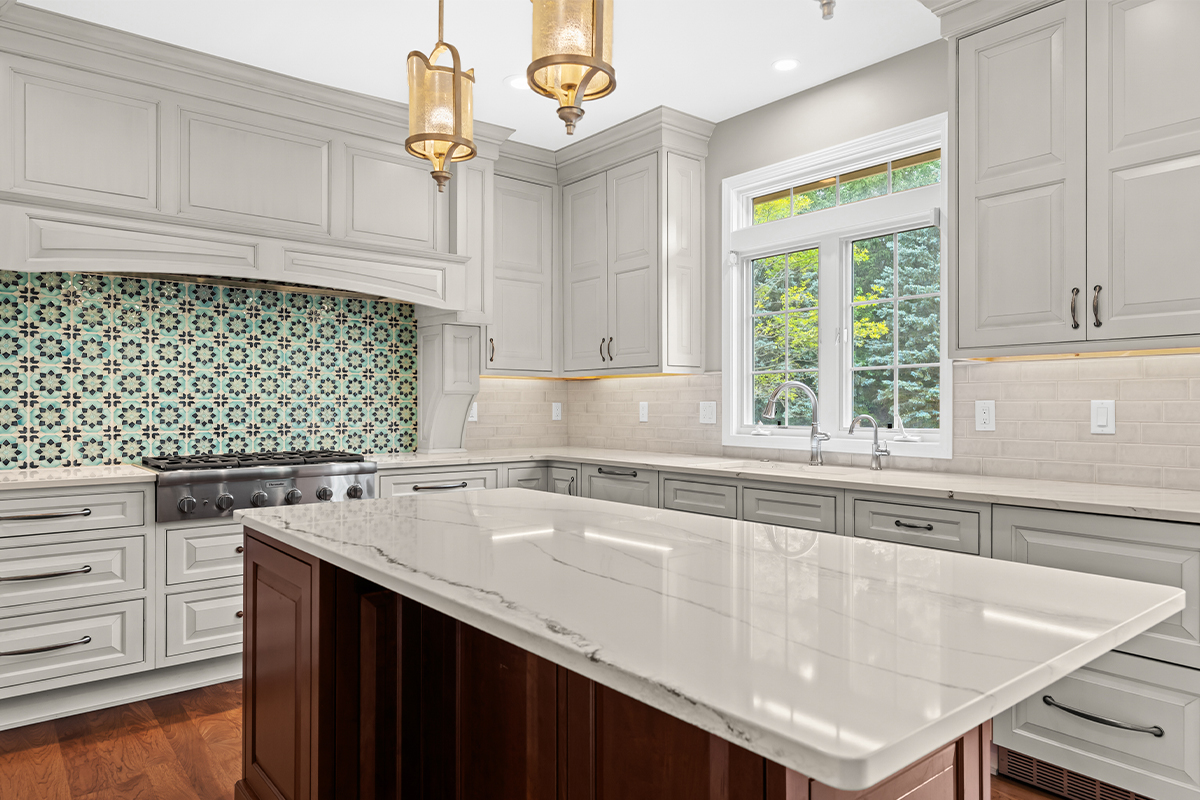 White kitchen perimeter cabinets with a dark cherry island.