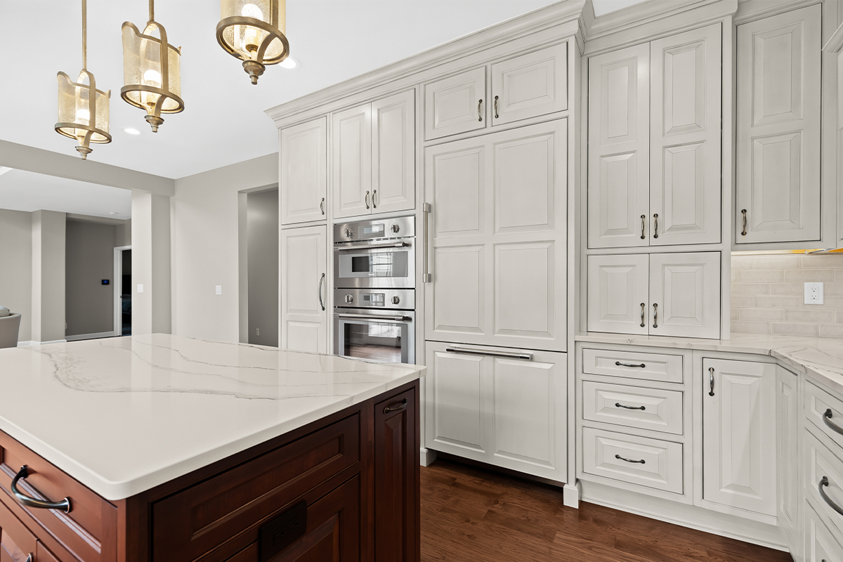 White kitchen perimeter cabinets with a dark cherry island.