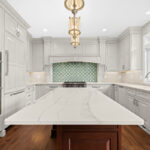 White kitchen perimeter cabinets with a dark cherry island.