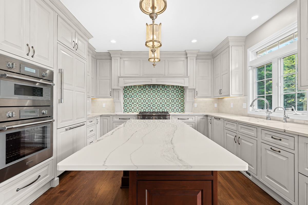 White kitchen perimeter cabinets with a dark cherry island.