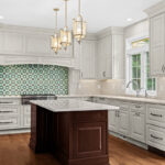 White kitchen perimeter cabinets with a dark cherry island.