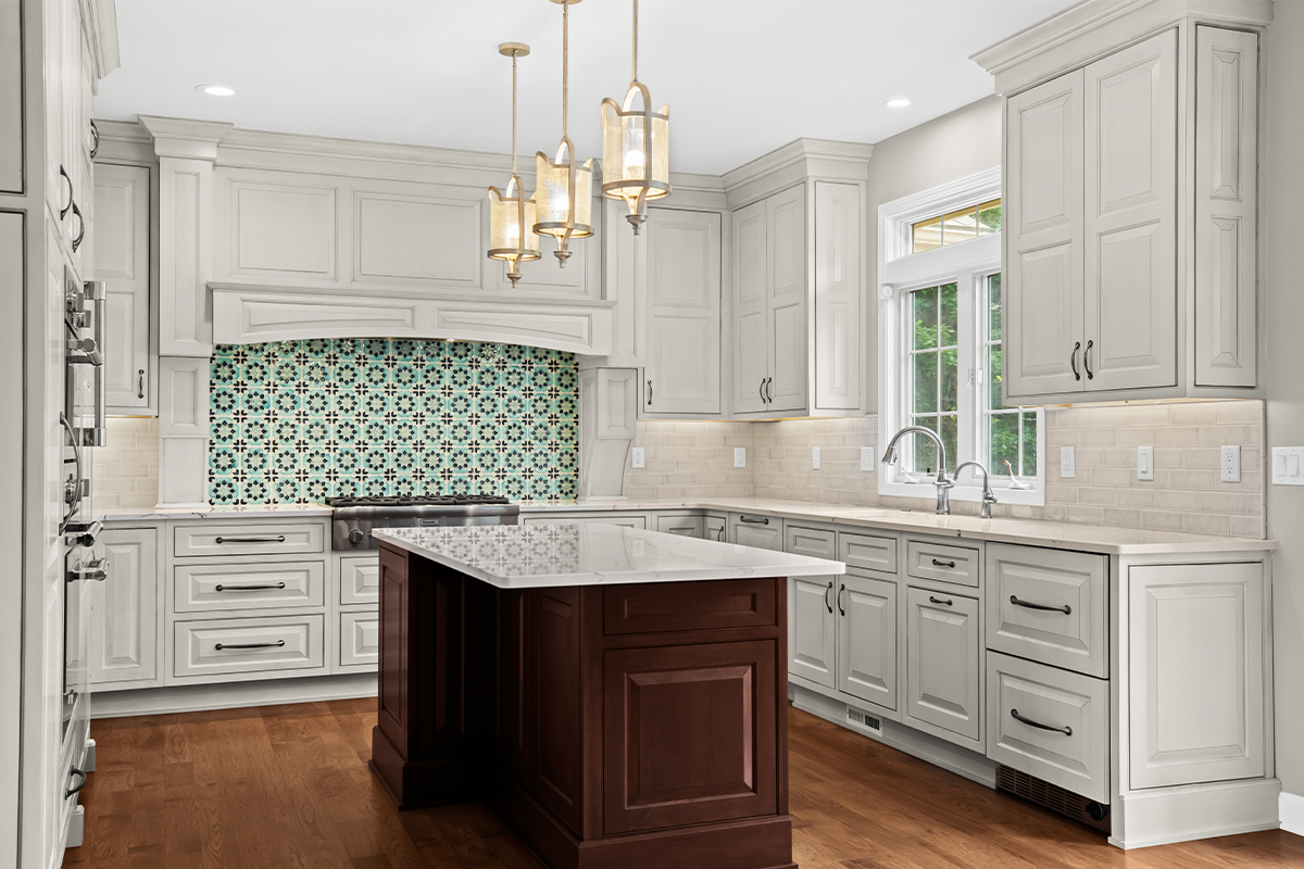 White kitchen perimeter cabinets with a dark cherry island.