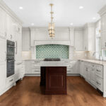 White kitchen perimeter cabinets with a dark cherry island.