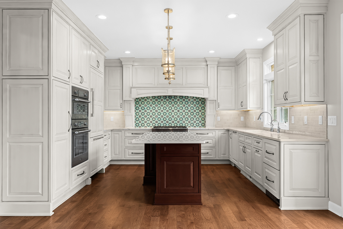 White kitchen perimeter cabinets with a dark cherry island.