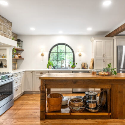 Old World style kitchen with Light Mocha-painted perimeter and a custom wood island in a mid-brown stain.