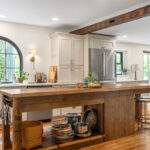 Old World style kitchen with Light Mocha-painted perimeter and a custom wood island in a mid-brown stain.