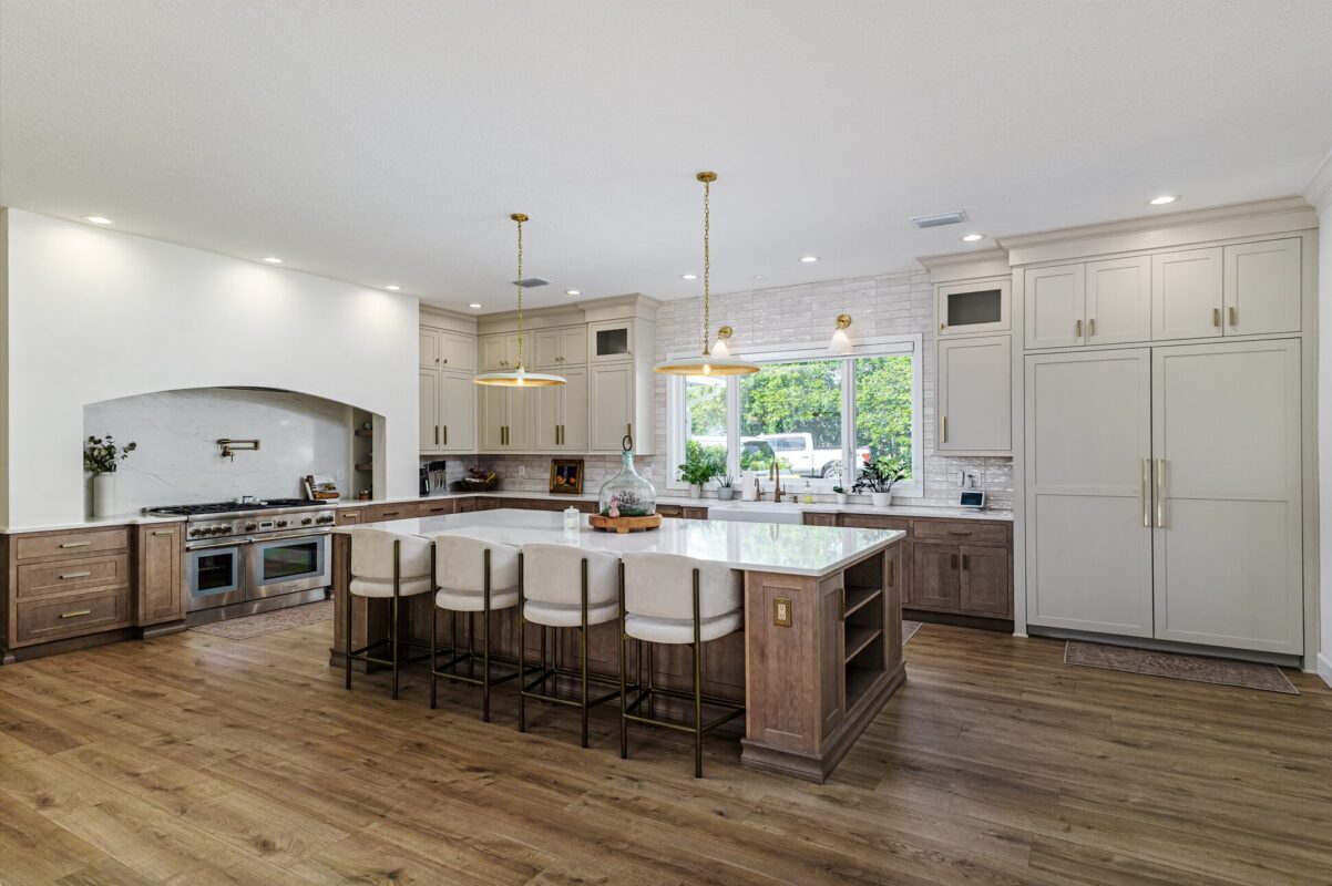 Light brown-stained lower and kitchen cabinets with gray painted uppers.