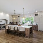 Light brown-stained lower and kitchen cabinets with gray painted uppers.