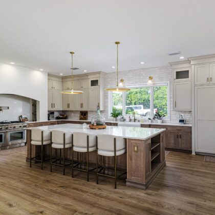 Light brown-stained lower and kitchen cabinets with gray painted uppers.