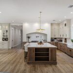 Light brown-stained lower and kitchen cabinets with gray painted uppers.