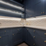 Blue-painted pantry cabinets with under cabinet lighting