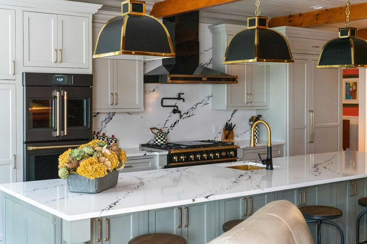 Painted Oyster primary kitchen cabinets with black appliances and green island.