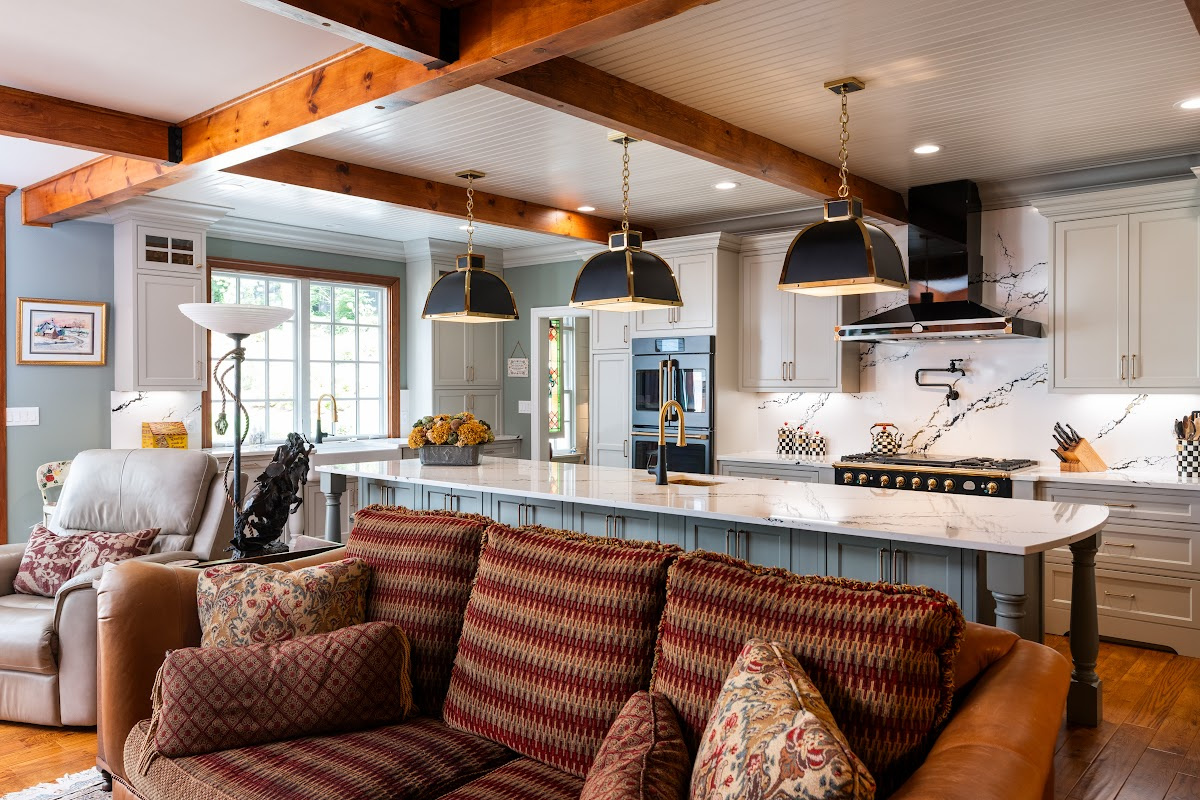 Painted Oyster primary kitchen cabinets with black appliances and green island.