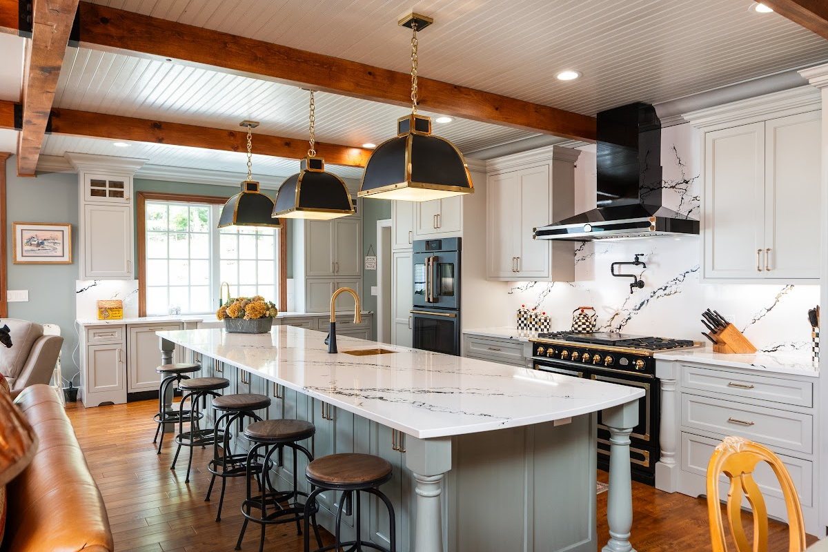 Painted Oyster primary kitchen cabinets with black appliances and green island.