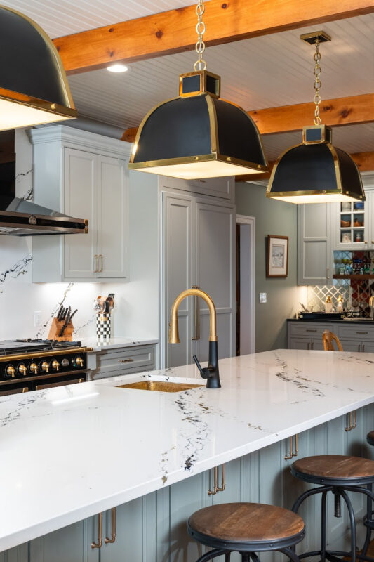 Painted Oyster primary kitchen cabinets with black appliances and green island.