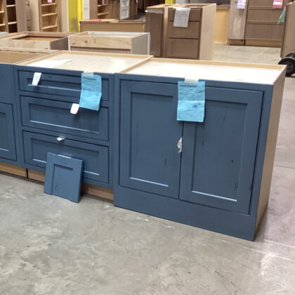 Full-height and three-drawer bases in a warehouse painted with a blue Labradorite paint on rustic alder.