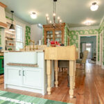 Custom cream paint colored island with natural wood extension furniture cabinet.