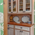 Hutch with natural wood cabinet frame and white doors and headers.