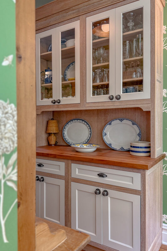 Hutch with natural wood cabinet frame and white doors and headers.