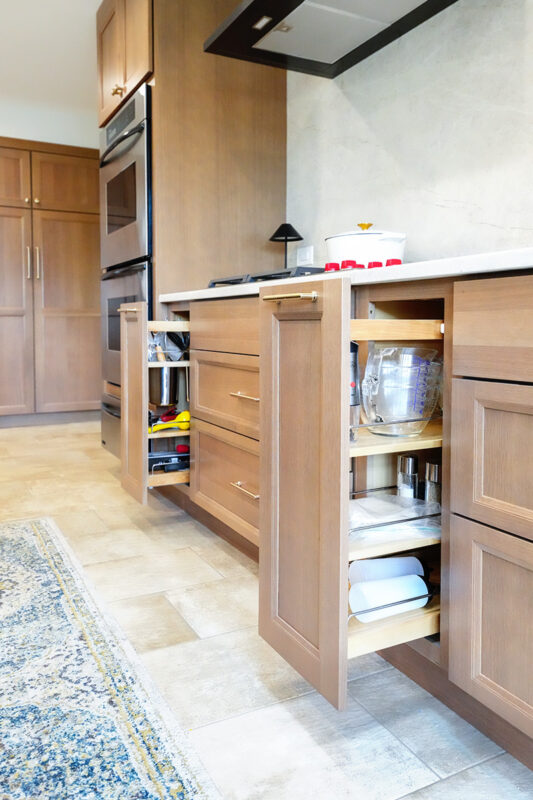 Kitchen cabinets with pullout accessory kits open.