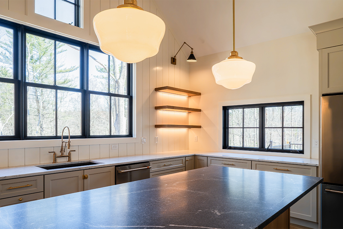 Light beige kitchen cabinets with hood and floating shelves.