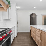 kitchen with white perimeter and stained rift white oak island cabinets.