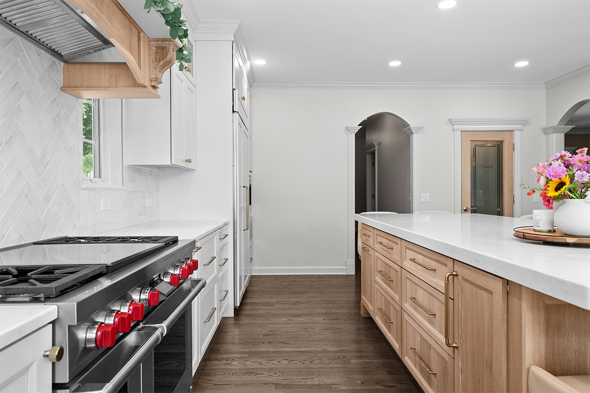 kitchen with white perimeter and stained rift white oak island cabinets.