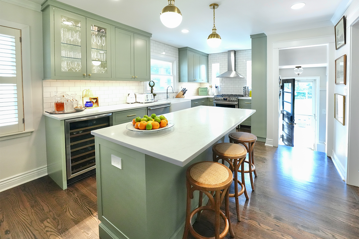 Light green painted kitchen with island.