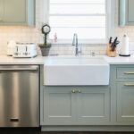 Light green painted kitchen with farmhouse sink