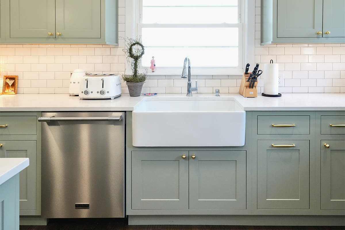 Light green painted kitchen with farmhouse sink