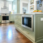 Light green painted kitchen with island.
