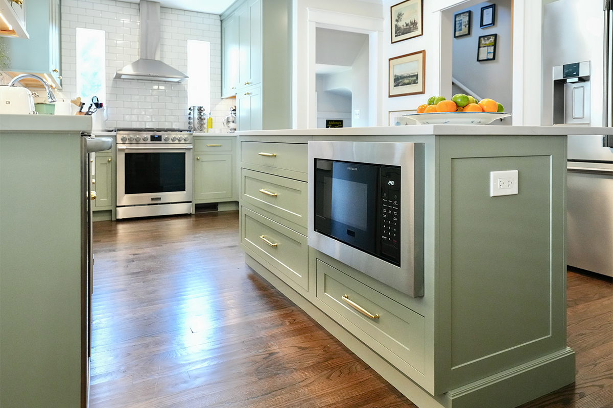 Light green painted kitchen with island.