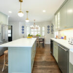 Light green painted kitchen with island.