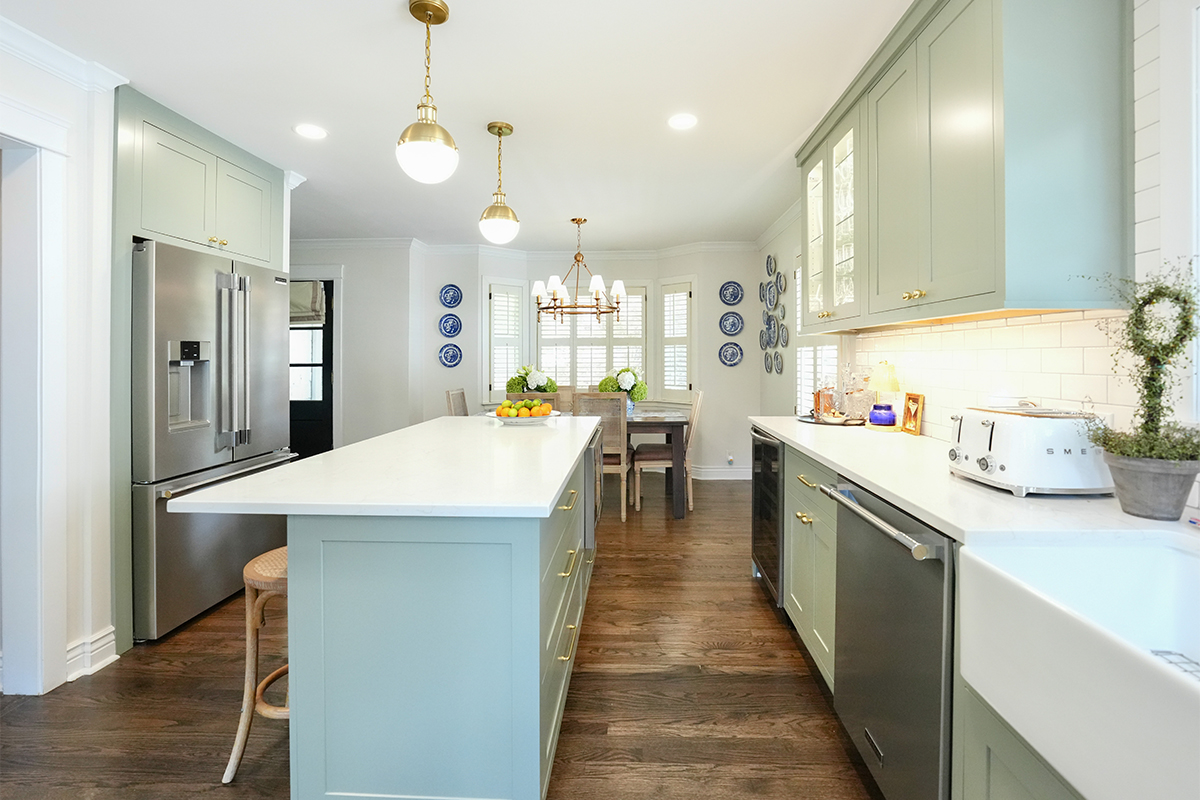 Light green painted kitchen with island.