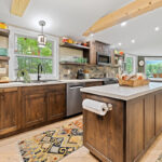 Rustic Alder kitchen with ceiling beams and floating shelves.
