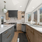 Kitchen cabinets with light brown stain. Shows a gray painted island.
