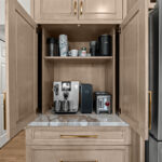 Kitchen cabinets with light brown stain. Shows pocket doors open in a coffee center cabinet.