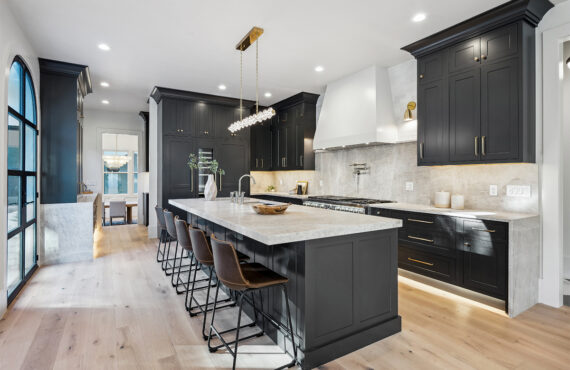 Kitchen with dark Iron Ore painted cabinets and a white hood. Includes a long island with seating.