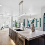 Kitchen with dark Iron Ore painted cabinets and a white hood. Includes a long island with seating.