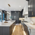Kitchen with dark Iron Ore painted cabinets and a white hood. Includes a long island with seating.