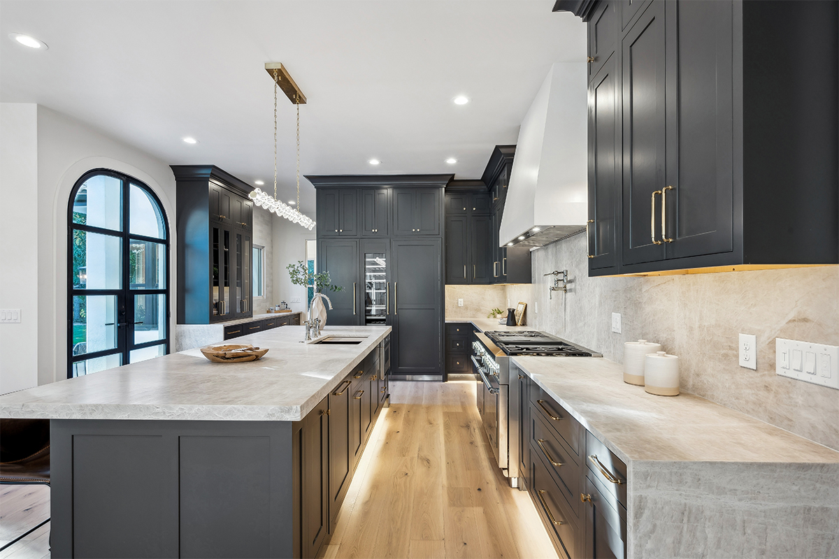 Kitchen with dark Iron Ore painted cabinets and a white hood. Includes a long island with seating.