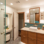 Bathroom with a stained vanity and white painted linen cabinets with powder desk mounted between them.