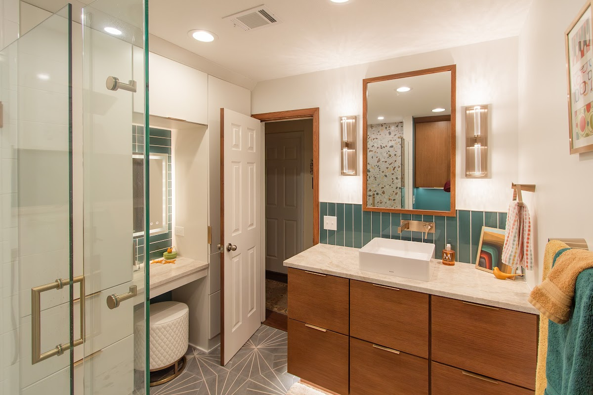 Bathroom with a stained vanity and white painted linen cabinets with powder desk mounted between them.
