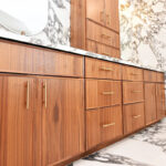 Walnut bathroom cabinets in Natural with walls and floors made of marble.