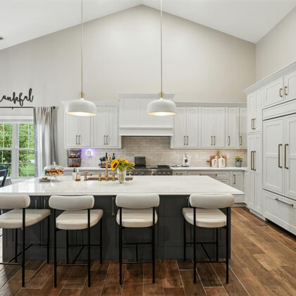 White kitchen perimeter cabinets with blue island.