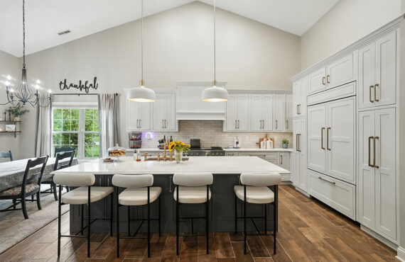 White kitchen perimeter cabinets with blue island.