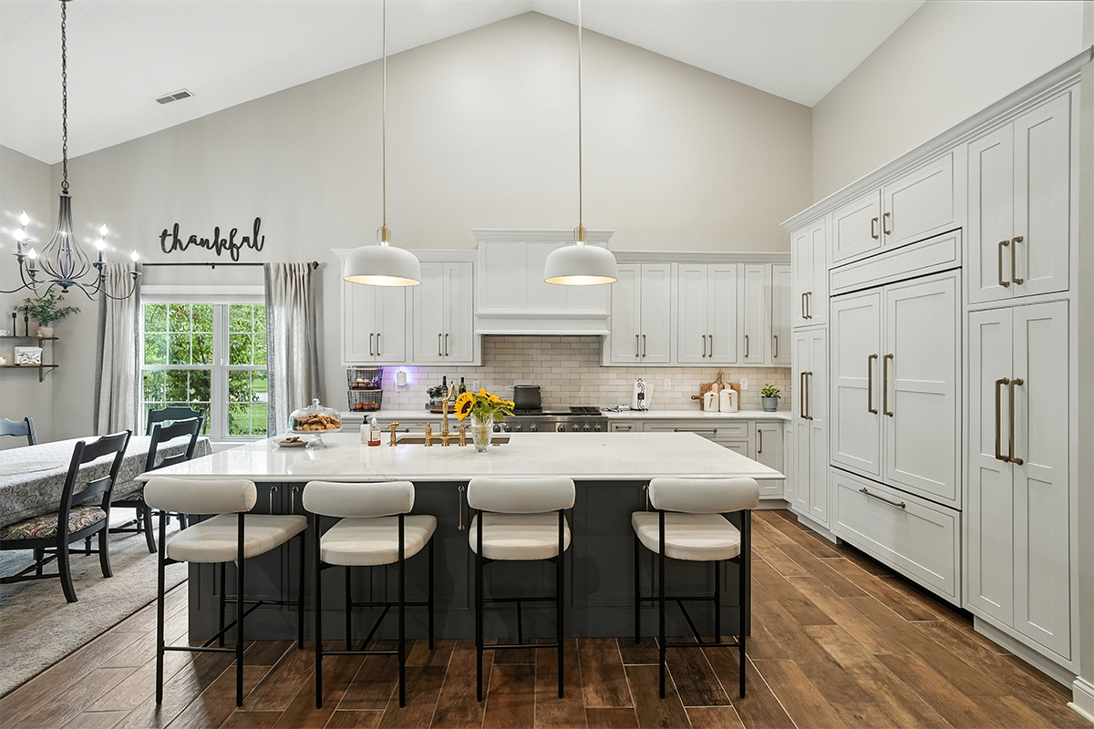 White kitchen perimeter cabinets with blue island.