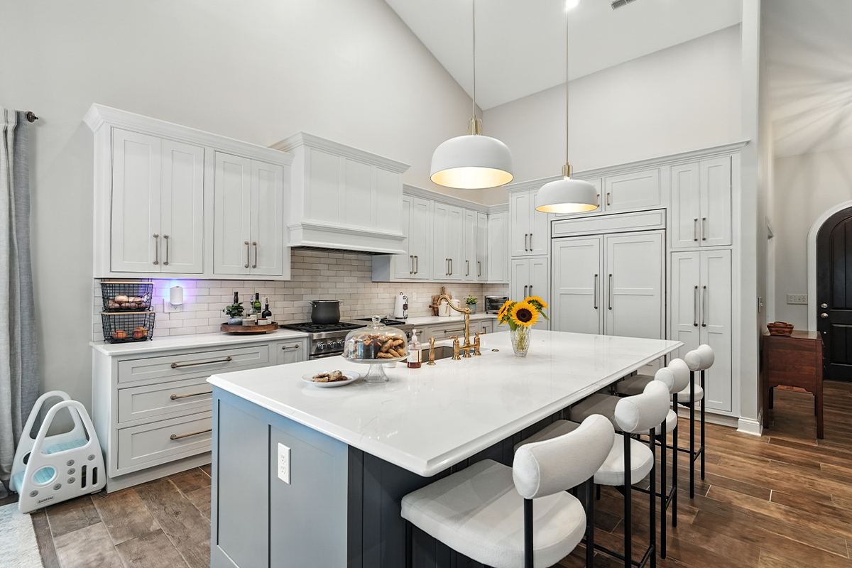 White kitchen perimeter cabinets with blue island.