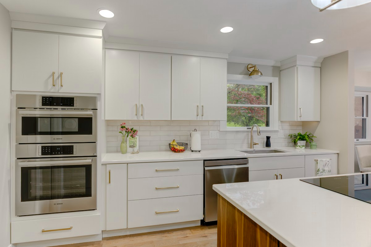 White painted kitchen cabinets with walnut natural island
